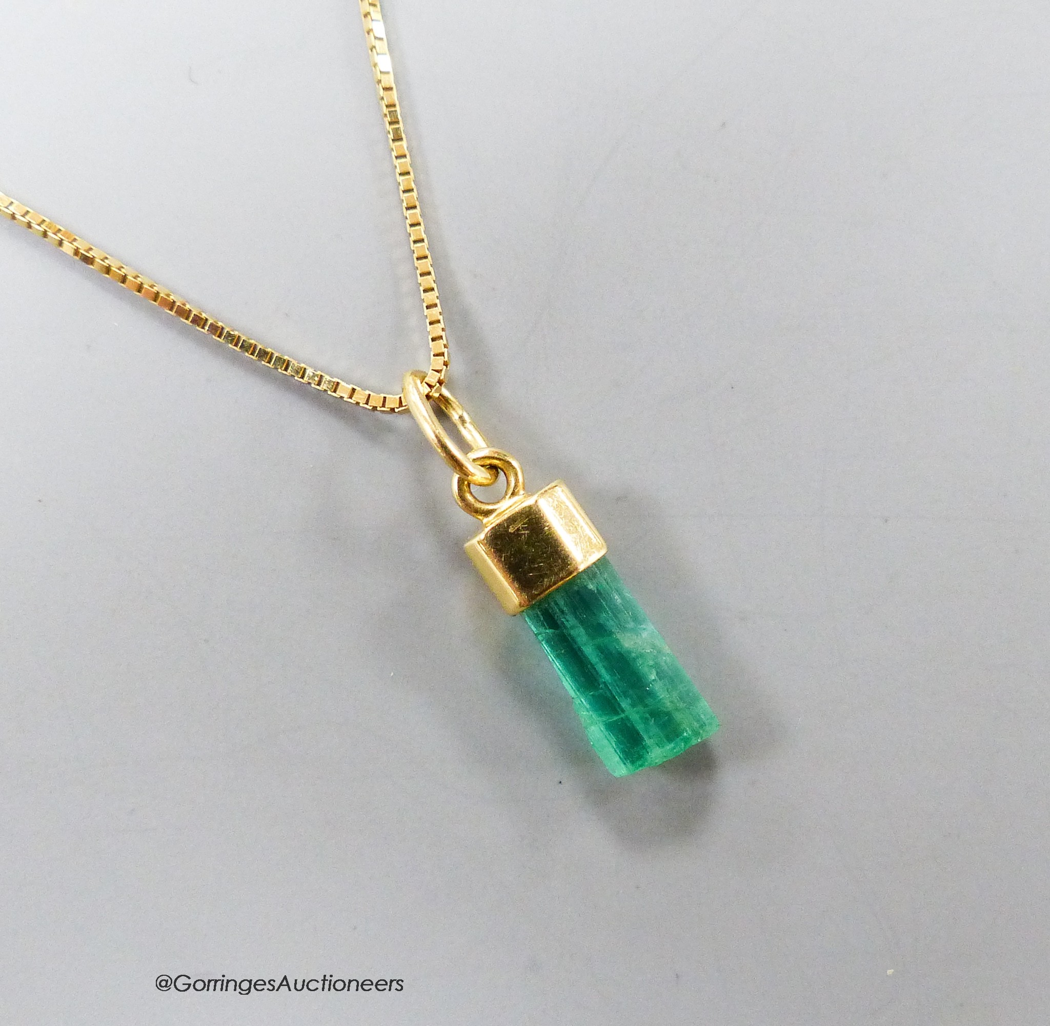 A modern Italian 750 yellow metal and emerald set pendant, 13mm, on a finelink chain, 39cm, gross weight 2.7 grams(stone a.f.).